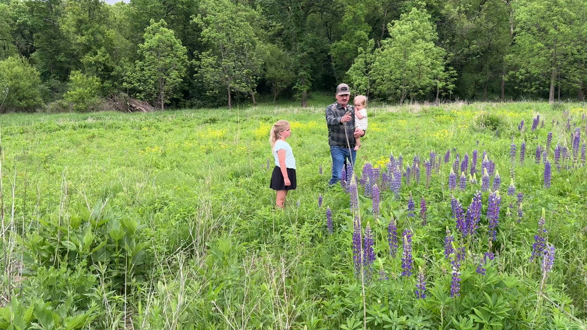 Jon Aleckson with his granddaughter in a prairie meadow